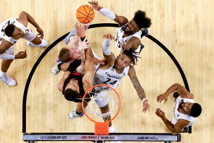 Cincinnati Bearcats guard Jeremiah Davenport (24), Cincinnati Bearcats center Hayden Koval (25) and Cincinnati Bearcats forward John Newman III (15) compete for a rebound against Southern Methodist Mustangs forward Tristan Clark (25) in the first half of an NCAA men s college basketball game, Thursday, Jan. 6, 2022, at Fifth Third Arena in Cincinnati. The Cincinnati Bearcats defeated the Southern Methodist Mustangs, 77-60. Southern Methodist Mustangs At Cincinnati Bearcats Jan 6 Smu